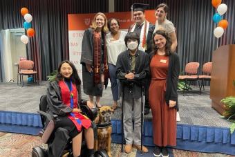 TIESplus graduates stand on stage and smile with Longhorn TIES coaches at Disability Graduation.