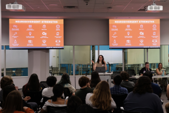 TIES coach presenting in front of a large group of UT students.