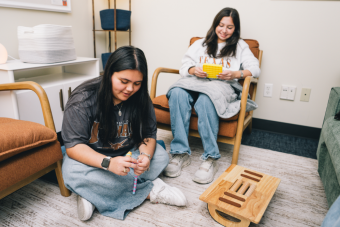 Two students smiling while fidgeting.