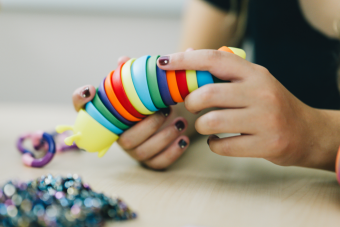 Person playing with a multi-colored fidget.