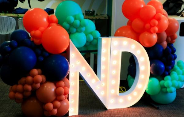 ND letters with orange, blue, and green balloons.